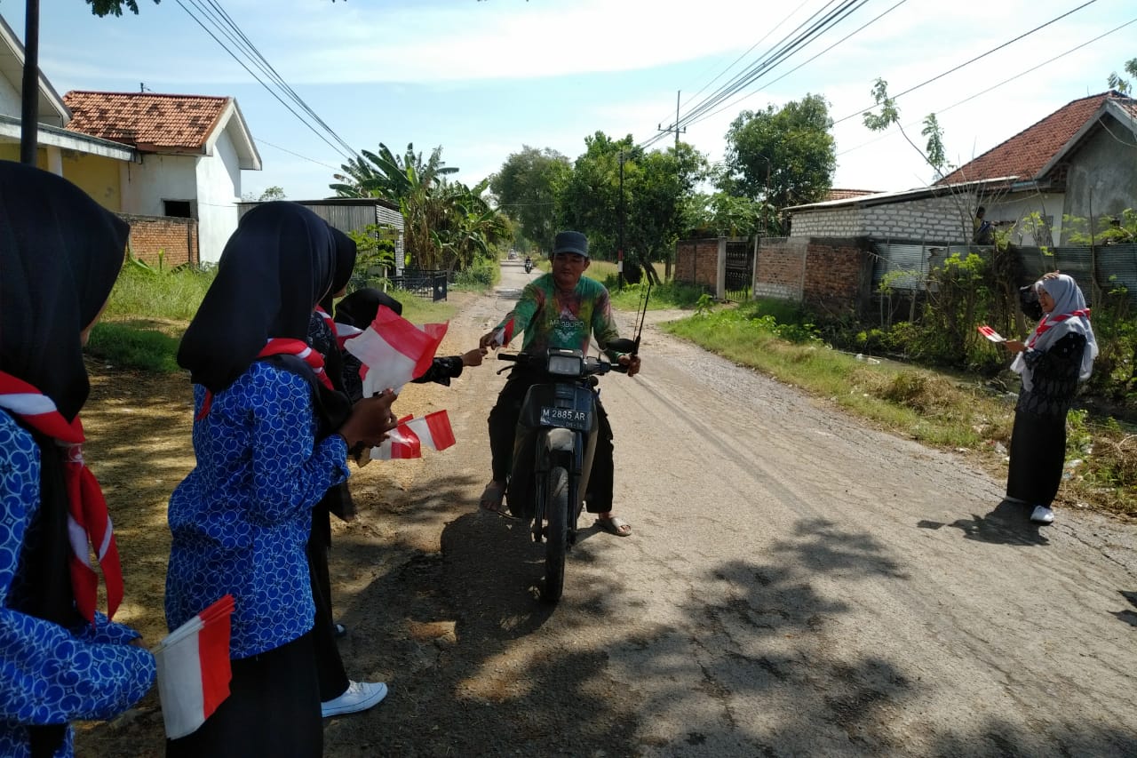 Peringati HUT ke 77 RI Siswa Bagi Bagi Bendera di Jalan Raya Blega-Sreseh