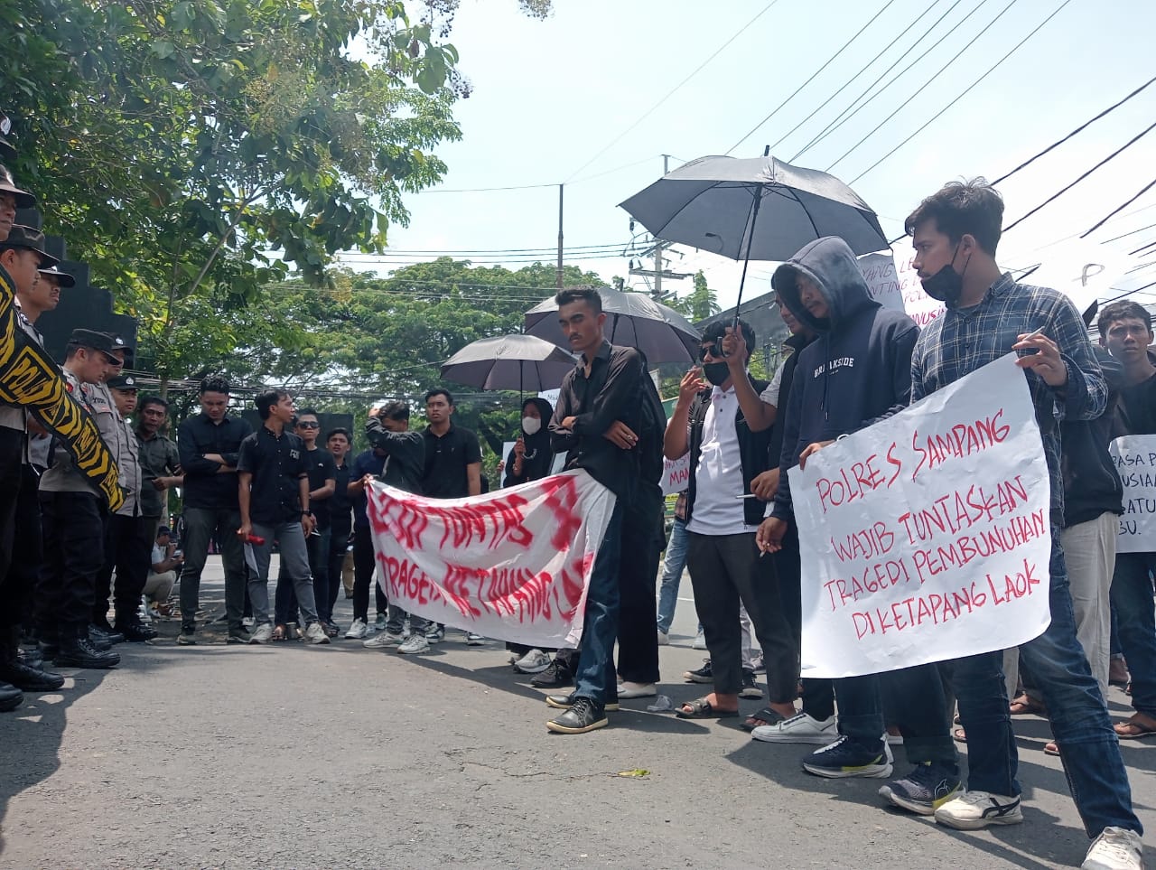 Polisi di Hadiahi Payung Hitam oleh Pendemo Buntut Tragedi Ketapang Laok