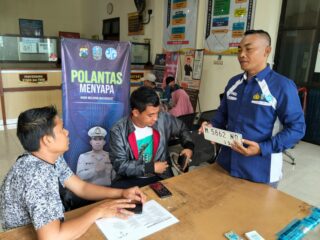 Caption foto: Petugas Satlantas Polres Sampang saat menyapa dan memberikan edukasi kepada masyarakat di Kantor Samsat Sampang.