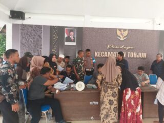 caption foto: Petugas Kecamatan Torjun bersama Pemerintah Desa Patapan mengawal proses penyaluran Bantuan Kesra kepada warga penerima manfaat yang berlangsung di Pendopo Kecamatan Torjun.