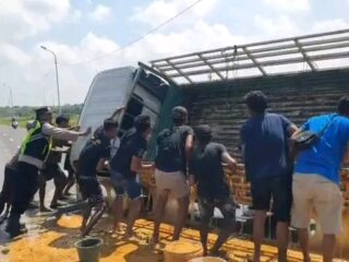 Caption Foto: Warga bersama anggota kepolisian mengevakuasi kendaraan pick up bermuatan petis yang terguling di JLS Sampang, Minggu (29/3/2026) pagi.