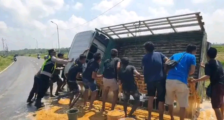 Caption Foto: Warga bersama anggota kepolisian mengevakuasi kendaraan pick up bermuatan petis yang terguling di JLS Sampang, Minggu (29/3/2026) pagi.