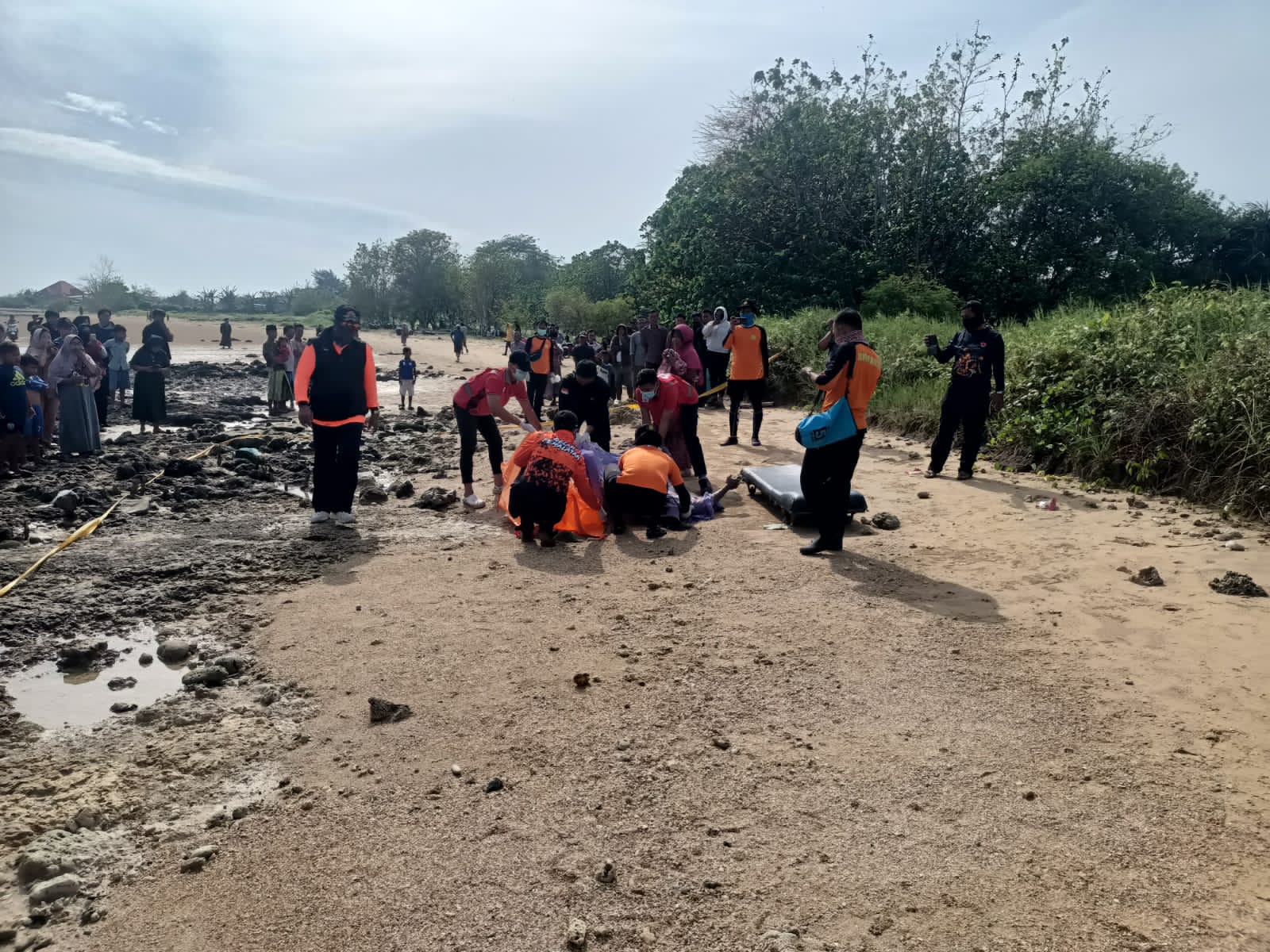 Caption Foto: Petugas kepolisian bersama warga saat melakukan evakuasi jenazah nelayan yang ditemukan di pesisir pantai Dusun Dung Gadung, Desa Jatra Timur, Kecamatan Banyuates, Kabupaten Sampang, Minggu (1/3/2026) pagi.