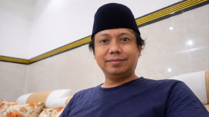 Caption Foto: Muhammad Masfur, Kepala Desa Pomola’an, Kecamatan Camplong, Kabupaten Sampang, tampil sederhana namun berwibawa. Ia dinilai sejumlah pihak sebagai figur yang mampu melanjutkan nilai kepemimpinan sosial almarhum Aba Gunjek melalui pendekatan humanis dan kedekatan dengan masyarakat.