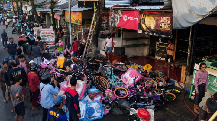 Caption Foto: Petugas Damkar Kabupaten Sampang saat melakukan proses pemadaman kebakaran toko onderdil sepeda angin di Jalan Tengku Umar, depan Pos Terminal Sampang, Sabtu (23/05/2026) sore.