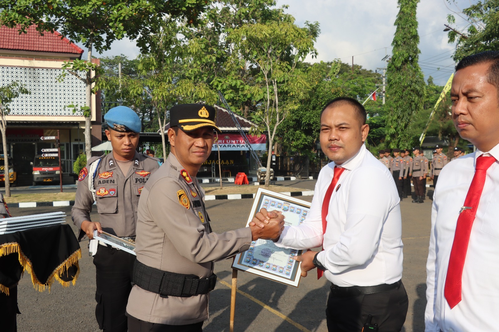 Caption Foto: Kapolres Sampang AKBP Hartono menyerahkan penghargaan kepada Kasat Reskrim Iptu Nur Fajri Alim bersama personel berprestasi atas keberhasilan mengungkap kasus dugaan asusila dengan 27 tersangka serta sindikat curanmor di 31 TKP dalam upacara reward dan PTDH di Mapolres Sampang, Rabu (15/7/2026).